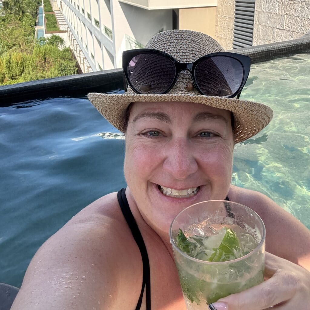girl with a cocktail in a rooftop infinity pool at an adult-only all-inclusive resort in Cancun