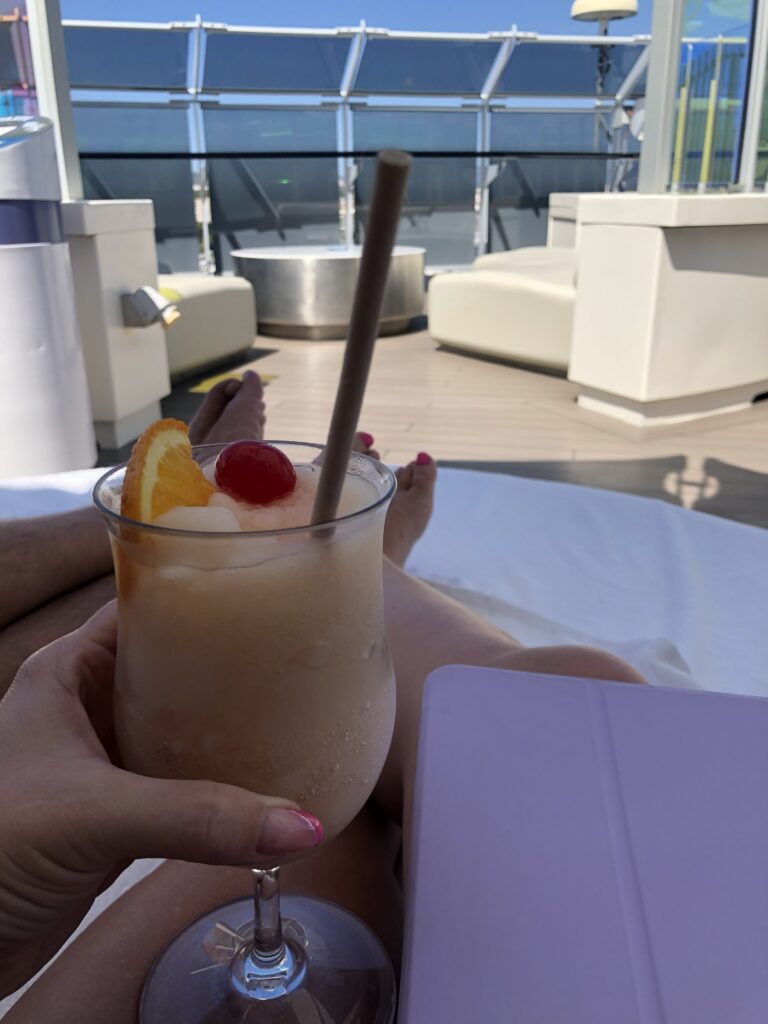 cocktail in hand while relaxing on deck on a cruise