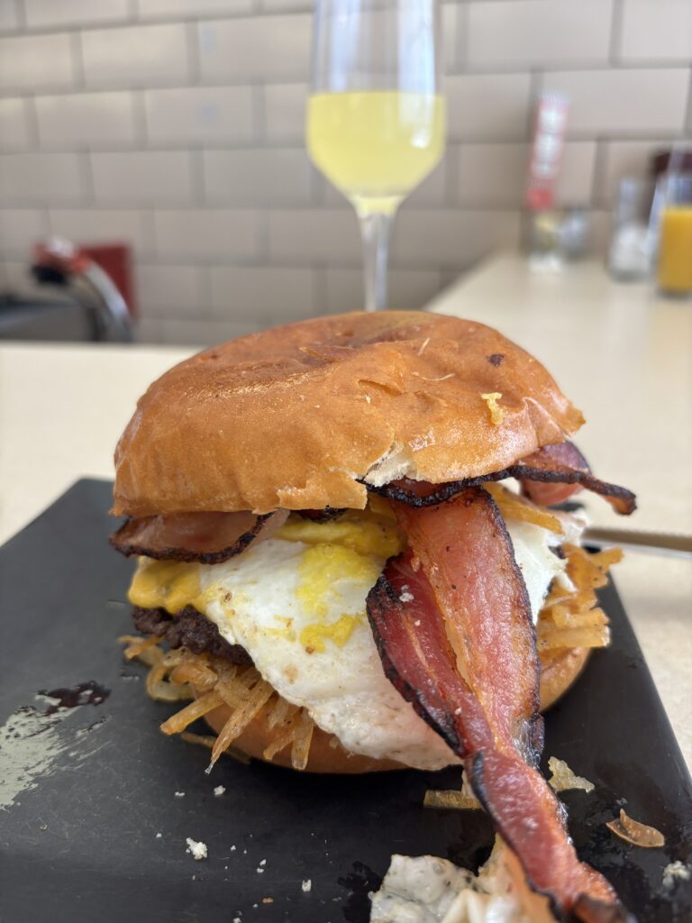 saving while traveling by enjoying a Brunch burger served at the counter in a mom and pop diner 